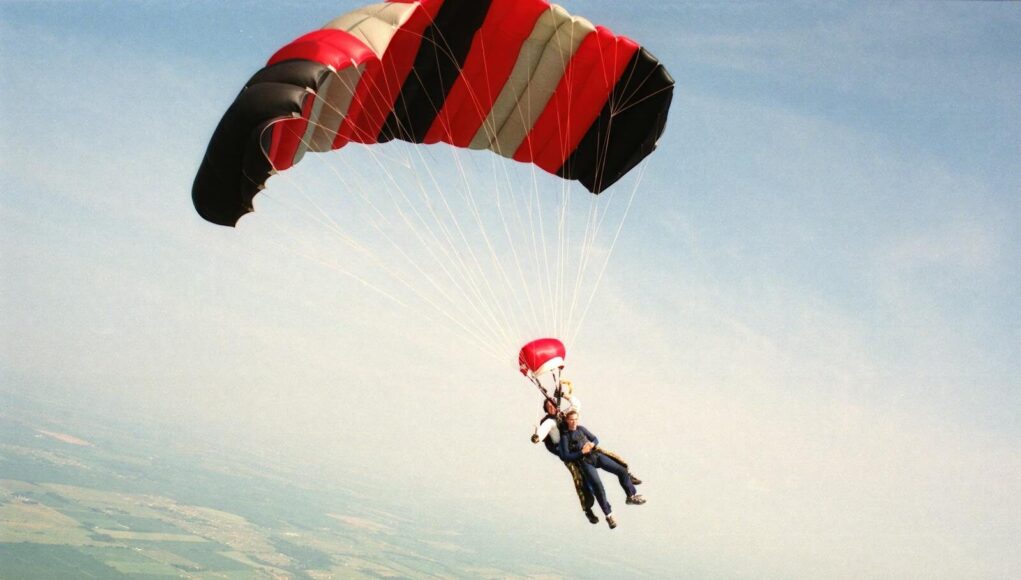Photo by Tom Fisk An exhilarating skydiving tandem dive over Baldwin, Wisconsin, under a vibrant parachute.