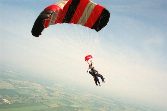 An exhilarating skydiving tandem dive over Baldwin, Wisconsin, under a vibrant parachute.