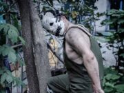 Aleksander Shablykin i tragedija u saveznoj državi Vašington: četiri žene ubijene u porodičnoj drami 2026. godine Creepy masked figure standing next to a Christian cross in a garden setting.
