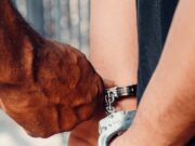 Bivši radnik američke ambasade osuđen na doživotnu kaznu zbog zlostavljanja devojčica u Burkina Faso Detailed image of handcuffing arrest procedure, highlighting law enforcement action.