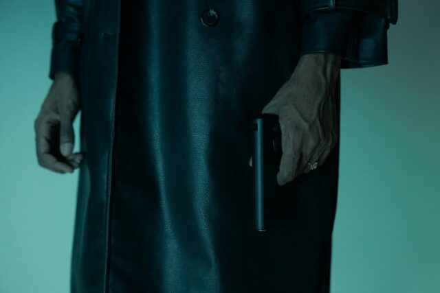 Close-up of an unrecognizable person holding a pistol, creating a mysterious and suspenseful mood.