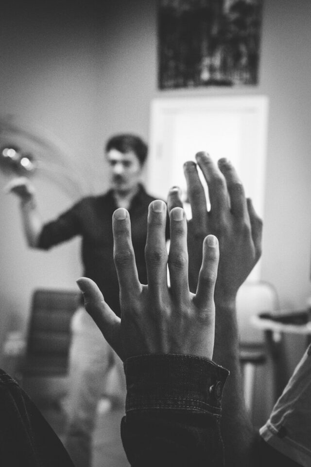 Photo by Artem Maltsev grayscale photography of two people raising their hands