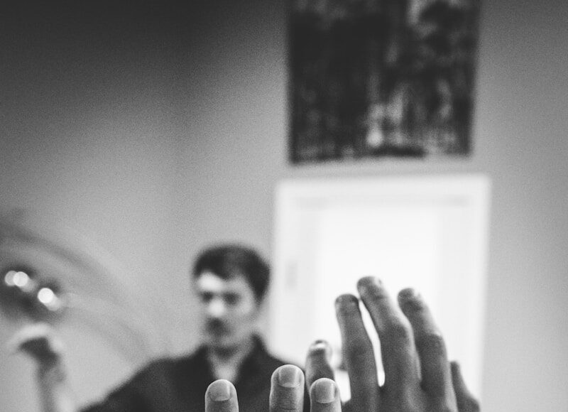 Photo by Artem Maltsev grayscale photography of two people raising their hands