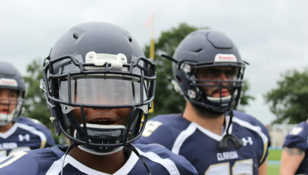 Close-up of American football players in action, wearing helmets and jerseys, showcasing team spirit.