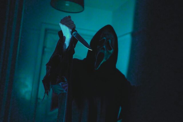 Photo by Nathan J Hilton Dark, eerie scene with a masked figure holding a knife, evoking horror film vibes.