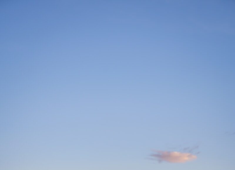 an airstream parked in a field with a blue sky in the background