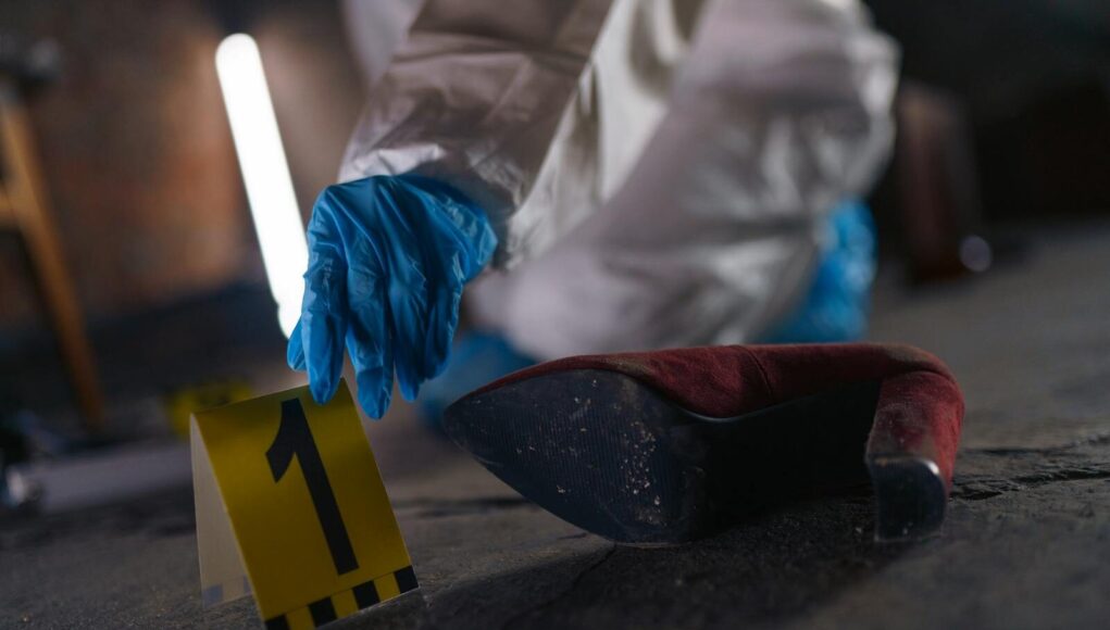 Crime scene investigation with shoe as evidence marked with number one and forensic glove.