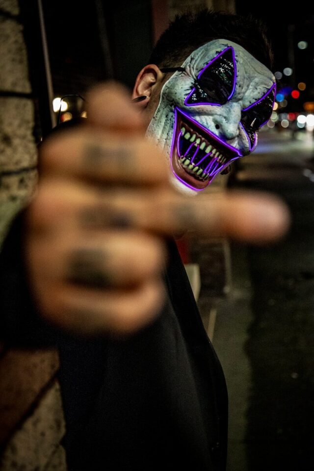 Photo by LexScope selective focus photo of man wearing white and purple clown face mask