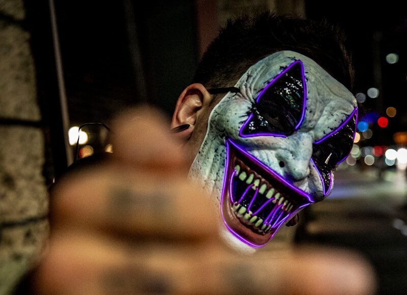 Photo by LexScope selective focus photo of man wearing white and purple clown face mask