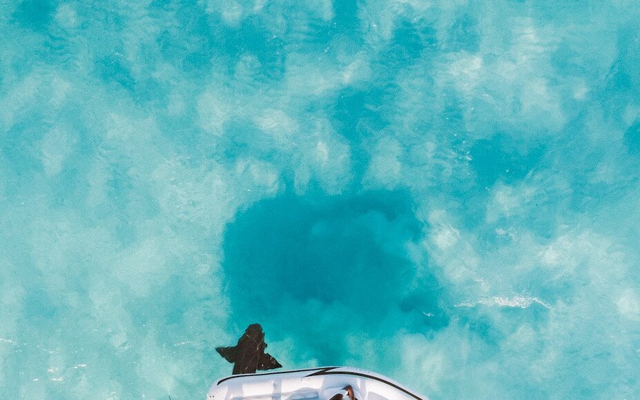 Photo by Jared Rice person sun bathing on white inflatable buoy under sunny skies
