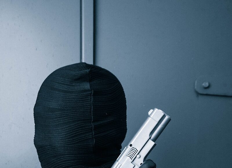 a man in a black suit holding a gun