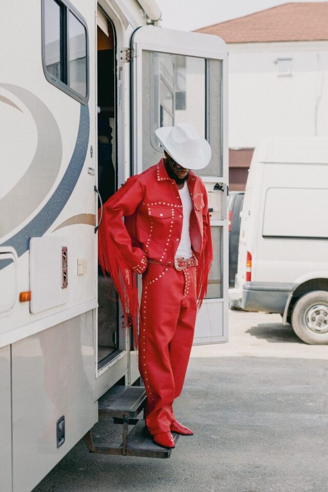 Photo by Ben Iwara Man in red cowboy outfit stands by rv