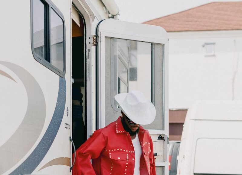 Man in red cowboy outfit stands by rv
