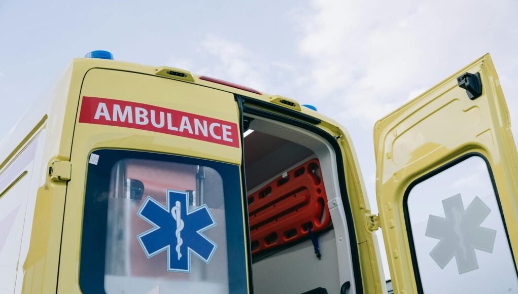 Yellow ambulance with open doors displaying medical interior equipment, emphasizing emergency response.