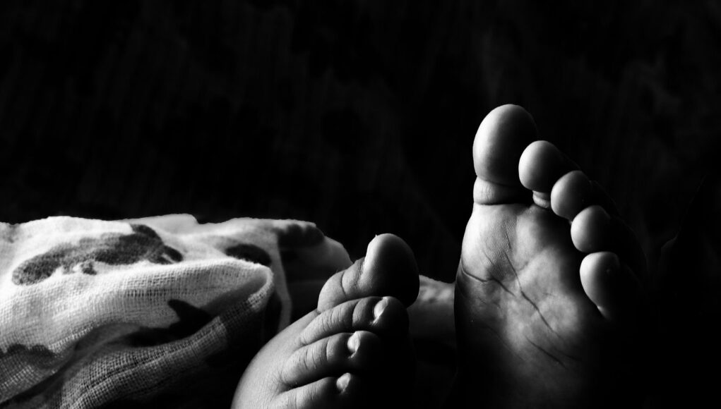beba, smrt Captivating black and white photo of an infant's feet, symbolizing innocence and new beginnings.
