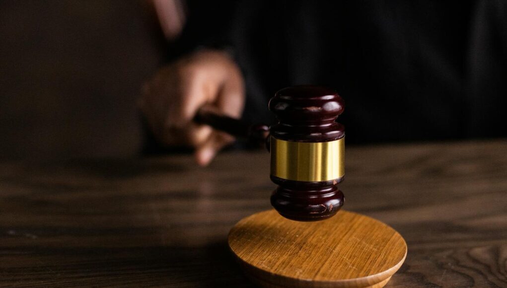 Photo by KATRIN BOLOVTSOVA A gavel striking a sound block, symbolizing justice and legal authority in a courtroom setting.