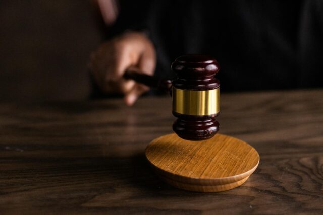 Photo by KATRIN BOLOVTSOVA A gavel striking a sound block, symbolizing justice and legal authority in a courtroom setting.