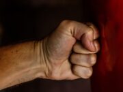 Vršnjačko nasilje: Kada dečja svađa preraste u ozbiljan problem A detailed close-up of a clenched fist striking a red surface showcasing strength.