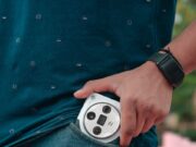HRONIKA MAGAZIN SAVETUJE! Kako se zaštititi od džeparoša tokom letnjih odmora Man placing a smartphone in a pocket, showcasing casual style with a smartwatch.