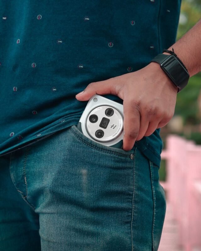 Photo by Rohit Sharma Man placing a smartphone in a pocket, showcasing casual style with a smartwatch.