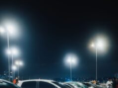 Automobil koji se pojavio na snimku: Trag koji je istražitelje odveo u drugom smeru A vivid night scene capturing a row of cars parked under bright streetlights in a spacious parking lot.