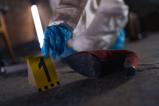 Photo by TREEDEO.ST Crime scene investigation with shoe as evidence marked with number one and forensic glove.