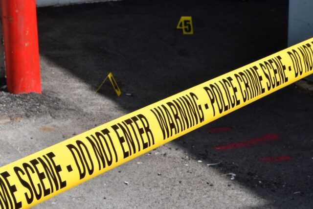 Photo by Siobhan Howerton Yellow police crime scene tape marking a restricted urban area on concrete ground.