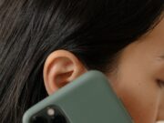 OTKRIVAMO! Slučaj koji počinje jednom prijavom: Kako sitna informacija prerasta u veliku istragu A woman with red nails holds a smartphone to her ear, close-up view.