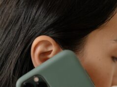 OTKRIVAMO! Slučaj koji počinje jednom prijavom: Kako sitna informacija prerasta u veliku istragu A woman with red nails holds a smartphone to her ear, close-up view.