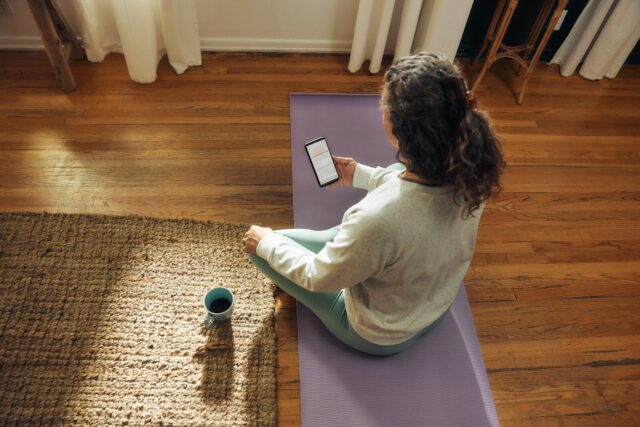 Photo by Microsoft Copilot Woman meditating on yoga mat with phone and drink